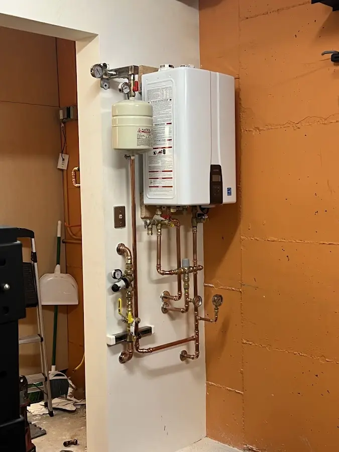 Plumbing technician inspecting water heater connections in Georgetown